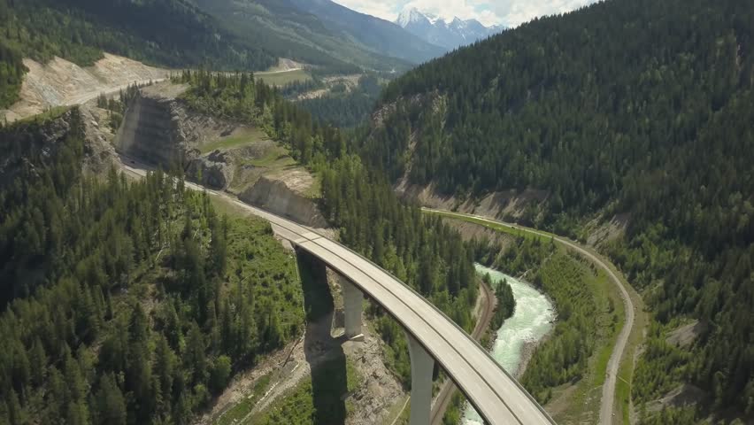 Aerial view of a scenic road surrounded by the Beautiful Canadian Mountains during a sunny summer morning. Taken near Golden, British Columbia, Canada.