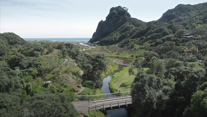Aerial: Creek, ocean and beach at Karekare Beach in the Waitakere Ranges, Auckland, New Zealand 