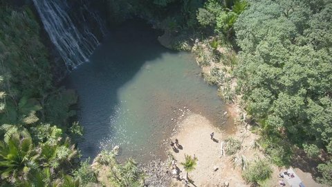 Aerial flying through a pohutukawa forest to KareKare waterfall. Auckland, New Zealand