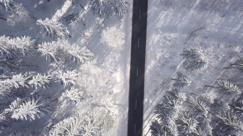 Sunny Aerial View car on snowy road in Winter Forest Germany