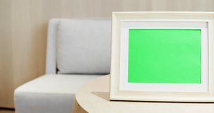close up of photo frame with green copys space on table at home