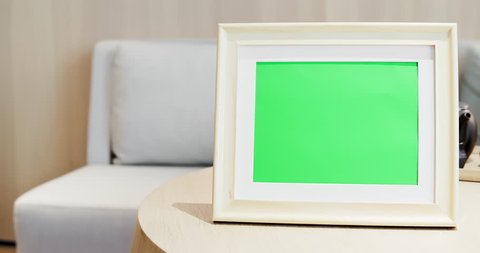 close up of photo frame with green copys space on table at home