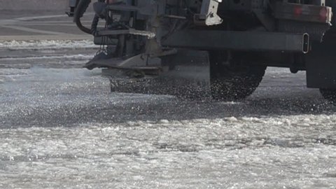 Ice service for cleaning of streets in winter. Machine sprinkle roads with salt and chemicals against road incidents. Super slow motion 1000 fps
