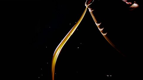 Motor oil pouring on black background.