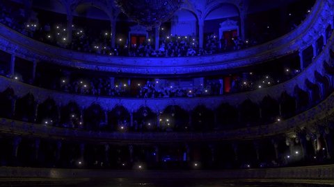 Hall of the Opera House with people with lights on, luminous telephones