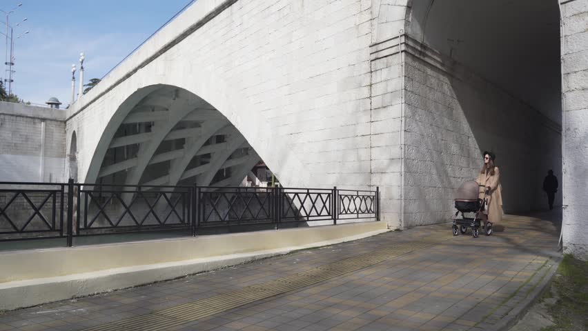 pretty girl walking down the street with baby carriage