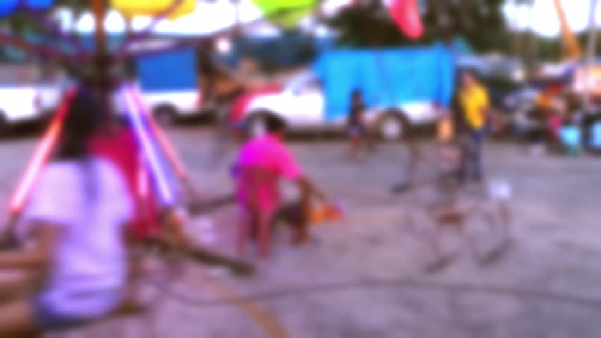 Blur of children swing in fair playground.