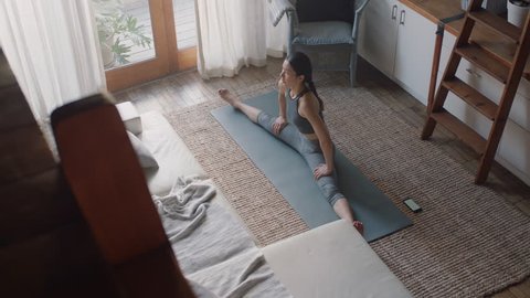 healthy asian woman exercising at home in living room stretching flexible body enjoying healthy fitness lifestyle practicing warm up exercise วิดีโอสต็อก