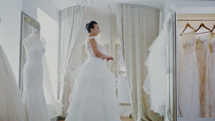 Beautifu bride choosing wedding dress in a wedding salon