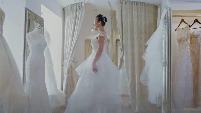 Beautifu bride choosing wedding dress in a wedding salon