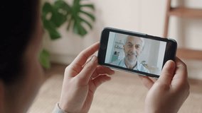 young woman having video chat using smartphone chatting to grandfather enjoying conversation sharing lifestyle communicating with mobile phone at home