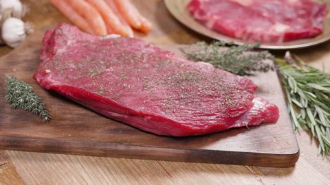 Fresh, raw meat set on a vintage looking surface. Sliding arround a chunk of juicy red meat.