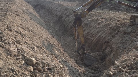 Loader backhoe, excavator digging a trench. Clip. Work of excavating machine on building construction site 4k clip