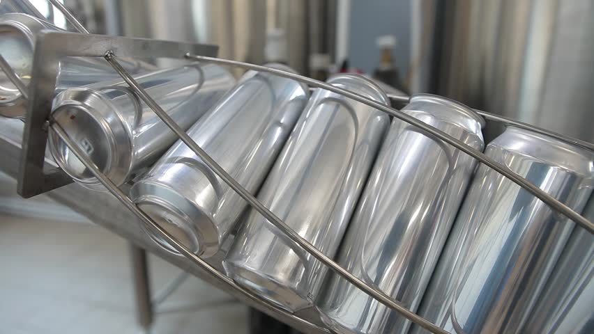 Conveyor for filling aluminum cans. Banks are moving along a conveyor belt.