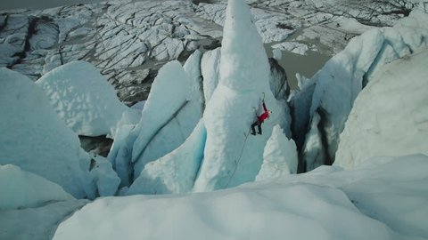 High angle scenic view of ice climber approaching peak of glacier using hooks / Palmer, Alaska, United States