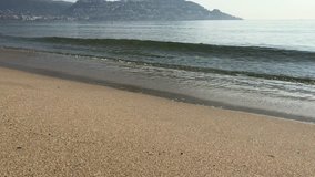 4K video of sea waves. Early morning. Small Spanish town Roses on the Mediterranean coast. Calm sea, quiet waves, empty beach, mountains with houses. Relax Video for advertising, design, clip, travel.