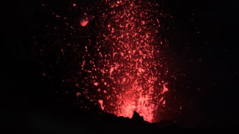 CLOSE UP, SLOW MOTION: Mount Yasur violently erupting and blasting hot magma out of its roaring depths. Dangerous chunks of scorching hot lava flying into the air during a powerful volcano eruption.