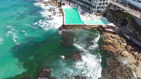 Beautiful bird's eye view shot of the turquoise rock pool of Ice Bergs with swimmers in it at Bondi Beach Sydney.
