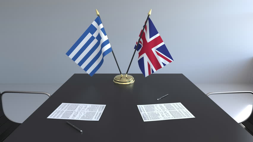 Flags of Greece and Great Britain and papers on the table. Negotiations and signing an international agreement. Conceptual 3D animation