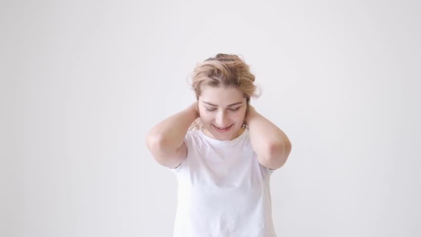 beautiful woman with red hair smiling fun and dancing in studio against white background