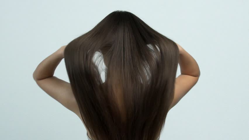 Woman moves long hair. Rear view. Girl shakes long straight hair. Female model is fluttering hair.   Slow motion footage. Rear view. Royalty-Free Stock Footage #1024513007
