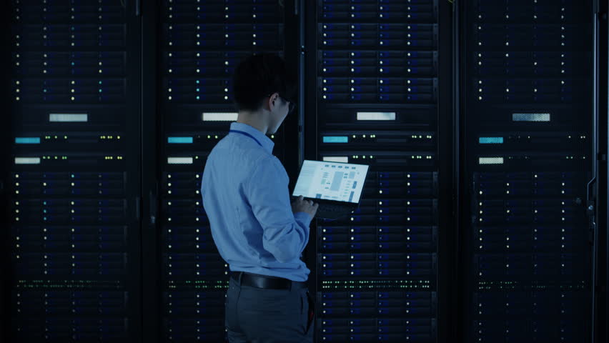 IT Specialist Standing In front of Server Racks with Laptop, He Activates Data Center with a Touch Gesture. Animated Concept of Digitalization of Information: Network of Lines Spreading Symmetrically Royalty-Free Stock Footage #1024515113