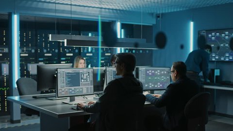 Team of IT Programers Working on Desktop Computers in Data Center Control Room. Young Professionals Writing on Sophisticated Programming Code Language. Elevated Moving Camera Shot