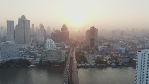 Aerial view over Bangkok city and Chao phraya river and Tak-sin bridge Saphan Taksin BTS train station in the morning with morning sun rise.
