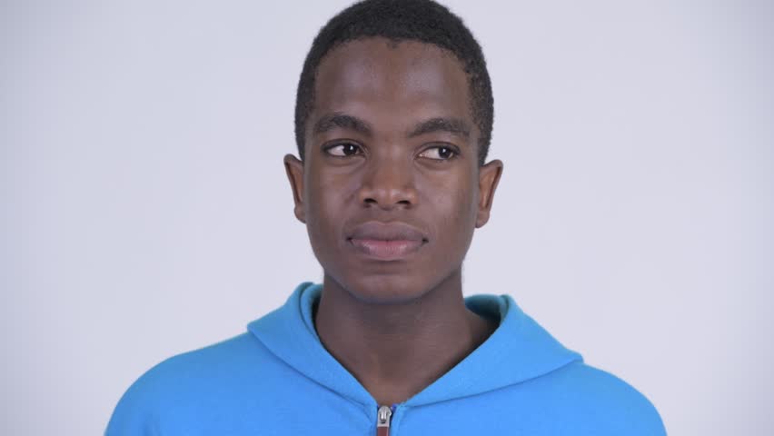 Face of young happy African man with finger on lips