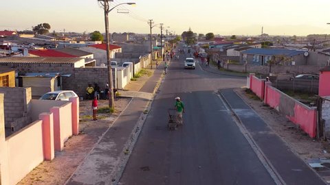 GUGULETHU, SOUTH AFRICA - CIRCA 2018 - Aerial over street scene in township of South Africa, with man and shopping cart walking on streets.