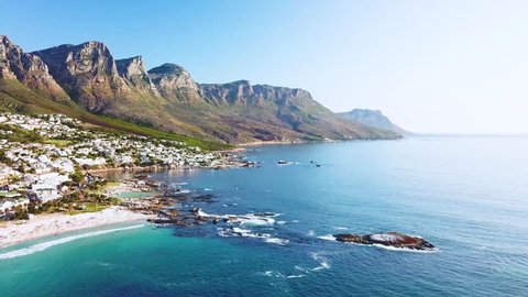 CAPE TOWN, SOUTH AFRICA - CIRCA 2018 - Aerial moving along the shoreline of Camps Bay, Cape Town, South Africa, with Twelve Apostles mountains.