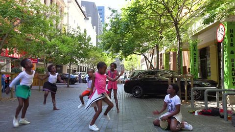 CAPE TOWN, SOUTH AFRICA - CIRCA 2018 - Young black children dance on the street of downtown Cape Town, South Africa.