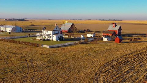 YORK, NEBRASKA - CIRCA 2018 - A drone aerial establishing shot over a classic beautiful farmhouse farm and barns in rural midwest America.