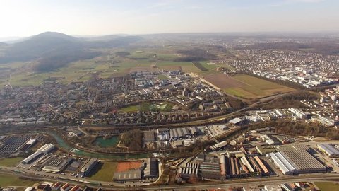 Aerial view drone film from Dornach towards Aesch and Reinach with France in background with winter forest without snow. CH Switzerland