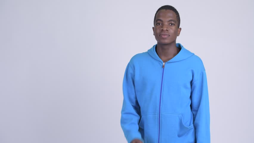 Young happy African man snapping fingers and showing something