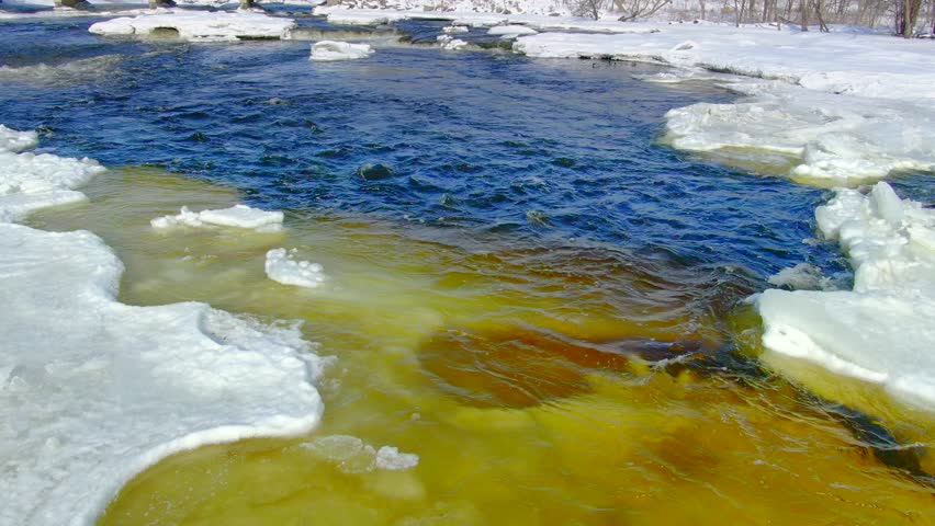 Water colder than the freezing point still flows in these icy rapids, as long as it keeps moving it remains liquid. Aerial view in Wisconsin Winter.