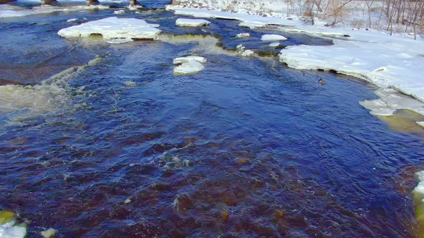 Water colder than the freezing point still flows in these icy rapids, as long as it keeps moving it remains liquid. Aerial view in Wisconsin Winter.