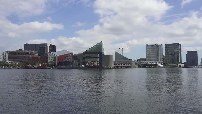Zoom in timelapse of the national aquarium at the Baltimore inner harbor on a bright cloudy day