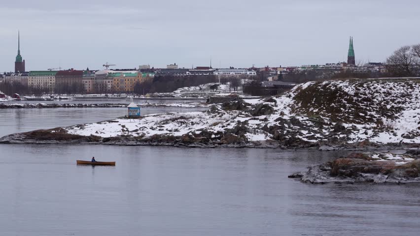 Editorial 01.20.2019 Helsinki Finland, man rows in the archipelago of Helsinki to a cliff where a other man is waiting