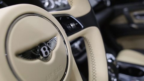 Moscow, Russia - February, 2019: Bentley Bentayga interior in black and cream colors. Closeup view of steering wheel with Bentley logo