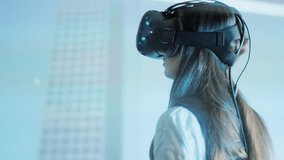 A young girl-client studies a design project in virtual reality glasses, looks around. Close-up, projection on the wall. The future of architecture and construction industry. Loft-office. Red epic. 4K