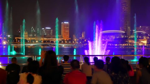 SINGAPORE – FEBRUARY 12, 2018: People watch Spectra, free light and water show at the Event Plaza on February 12, 2018. Pan at the end of the shot.