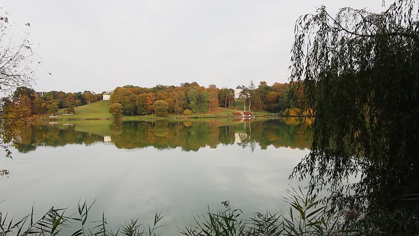 Manor on the shore of the autumn pond, Manor in the autumn park at sunrise, manor house in autumn forest on the lake