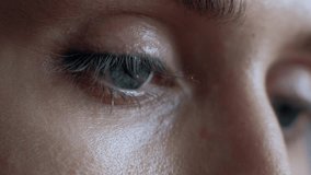 The female eye cries and tears are flowing macro video. Close-up woman eye cries and tears flow. 4k. Macro shoot.