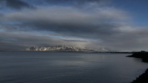 Time-lapse 4K: Seaside view and the dramatic sky above the fjords. View from the embankment of Reykjavik.