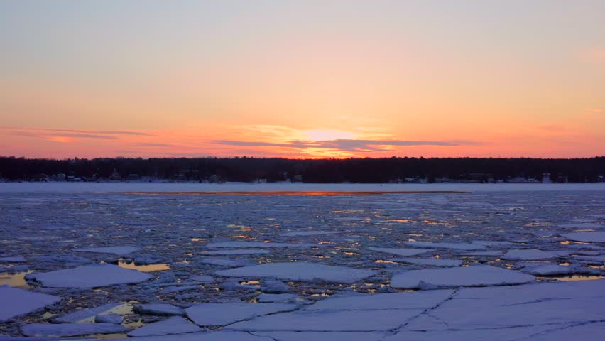 Flying slow towards sunset over broken ice in Sturgeon Bay, Wisconsin