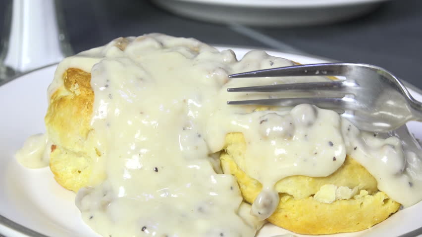 Closeup of eating biscuits and gravy, slow motion