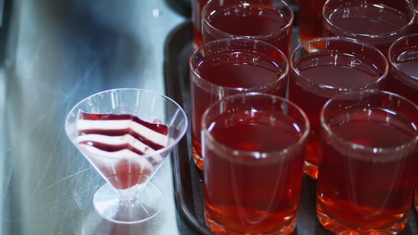 close-up, showcase with with drinks and desserts in canteen, mess hall, cafeteria, Food Buffet resturant. buffet worker lays out striped jelly desserts on showcase of self-service food Canteen