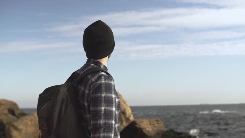 Young male traveler with photo camera on the beach