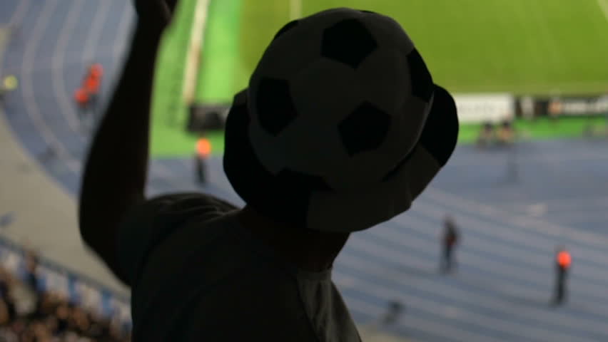 Football supporter blowing in horn at stadium, friends celebrating goal, joy | Shutterstock HD Video #1024637618